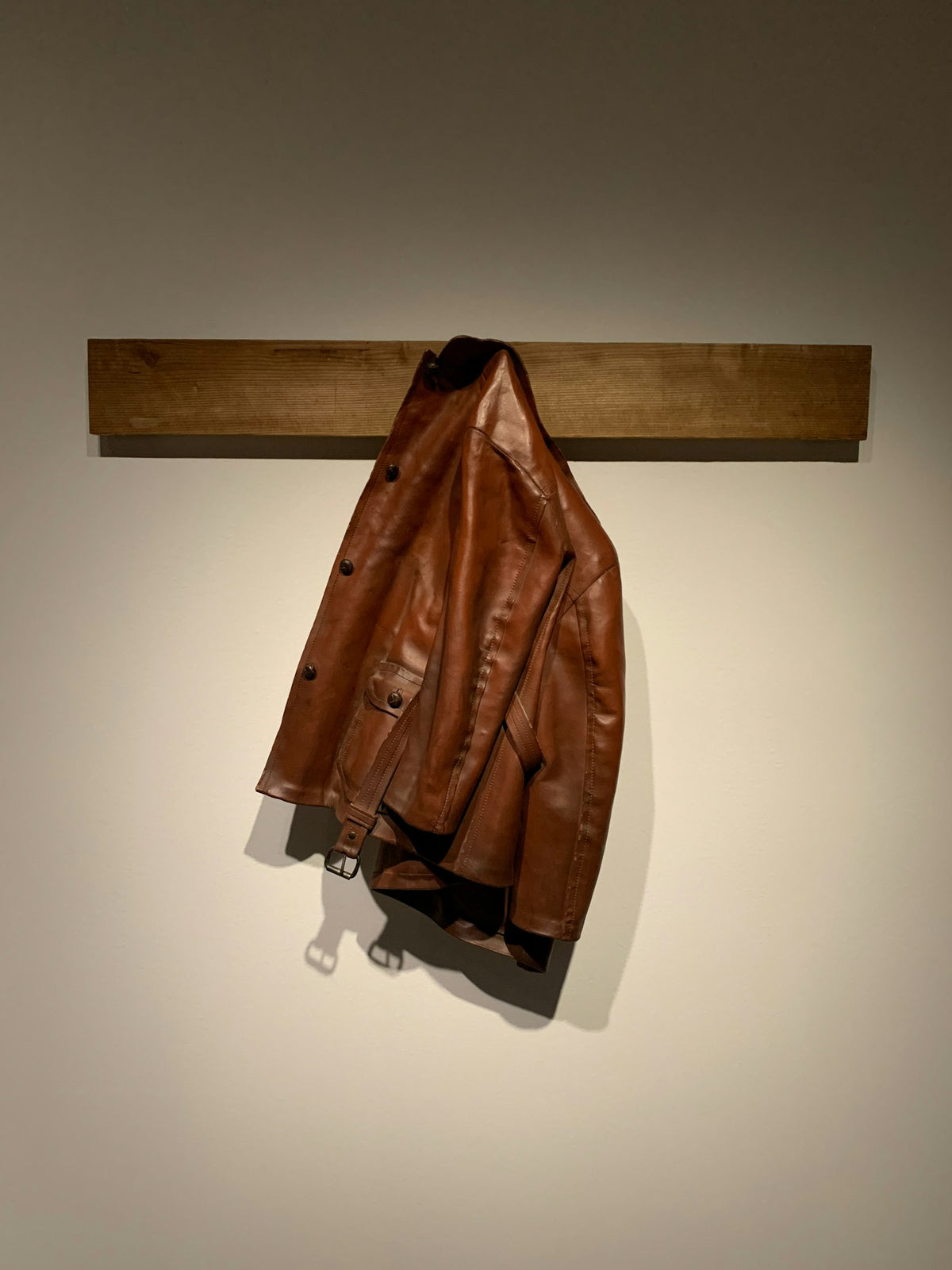 Tan leather jacket hanging on a hook