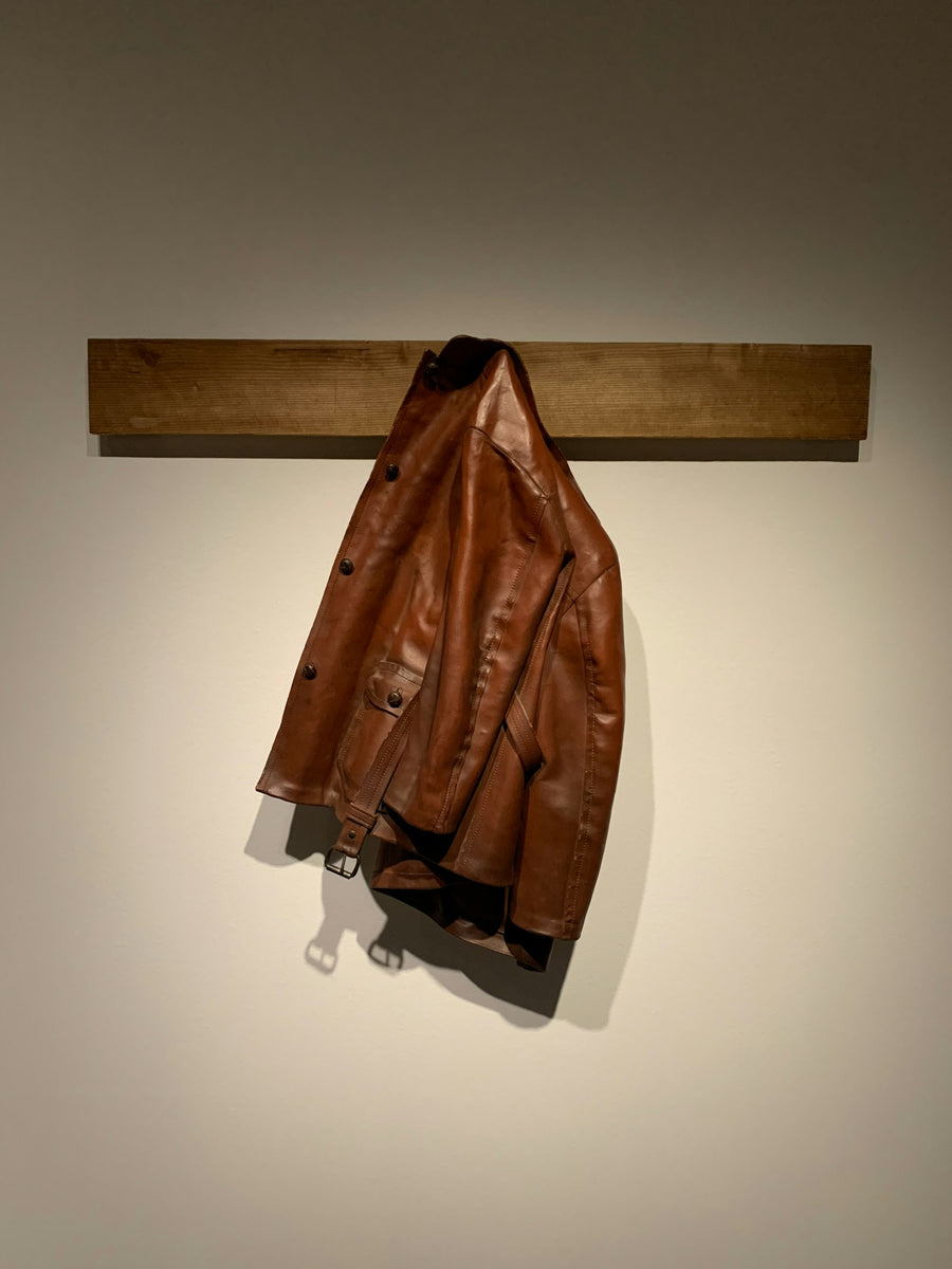 Tan leather jacket hanging on a hook